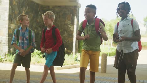 video de niños felices y diversos caminando y hablando frente a la escuela