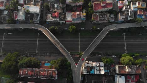antena de arriba hacia abajo del viejo puente oxidado con coches de conducción en la región pobre de la india