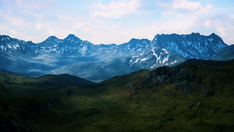 sunny landscape with views of snow-capped mountains and meadow