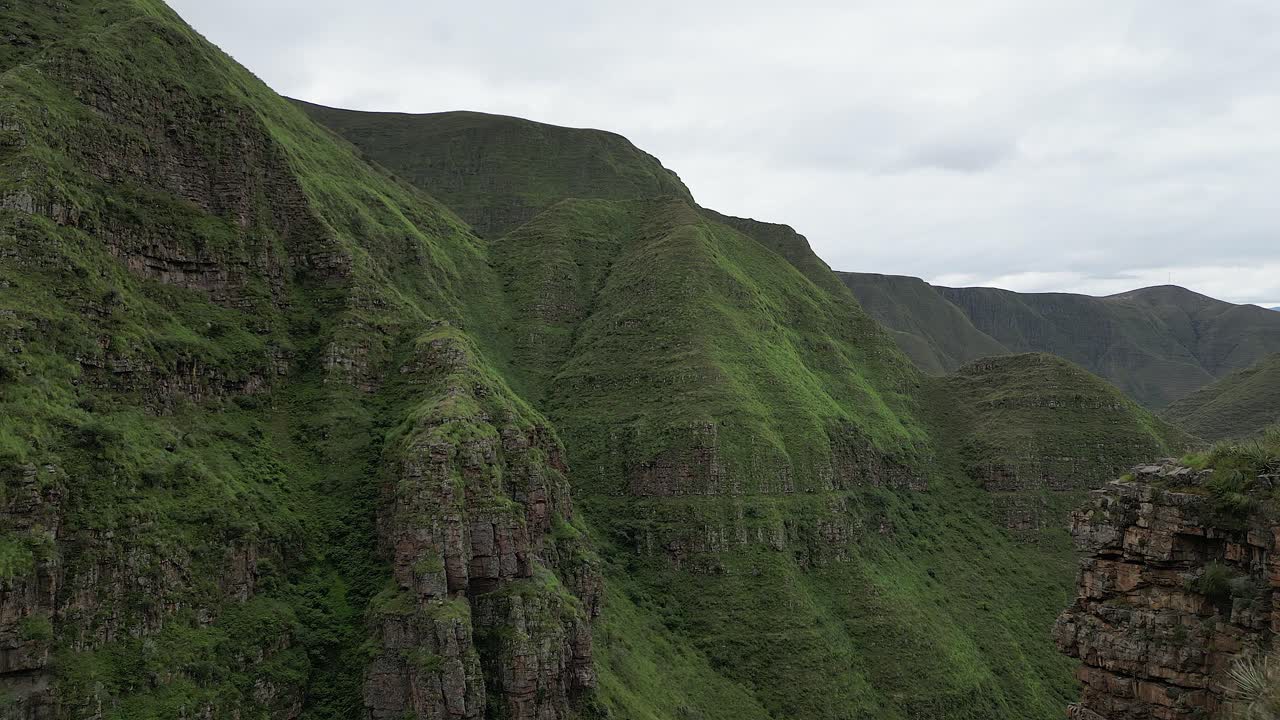 공중 비행: 가파른 잔디 인 바위 산 절벽이 외 계곡으로 떨어집니다.