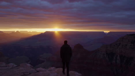 dramatic sunset over the grand canyon with a solitary figure