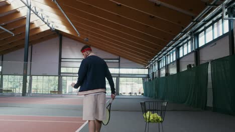 man playing tennis in an indoor court