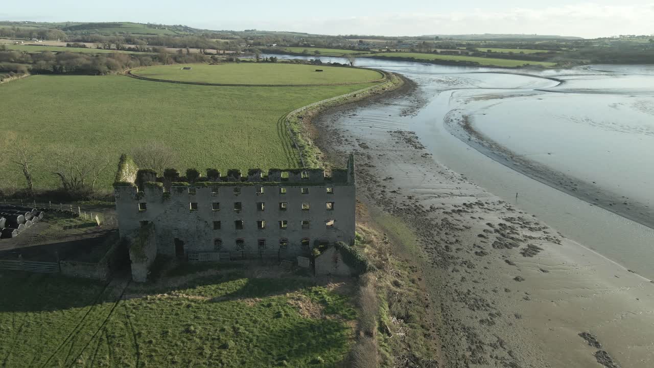 Et gammelt slott ved elven Blackwaters bredder i County Cork, Irland, på en solrik dag, luftfoto.