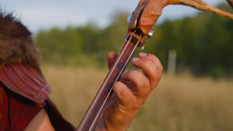 Músico-Folklórico-Presiona-Cuerdas-En-Cubierta-Tocando-Ikili-En-El-Campo