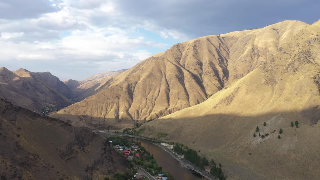 Aerial drone shot of Salmon river and town of Riggins Idaho through high mountains.