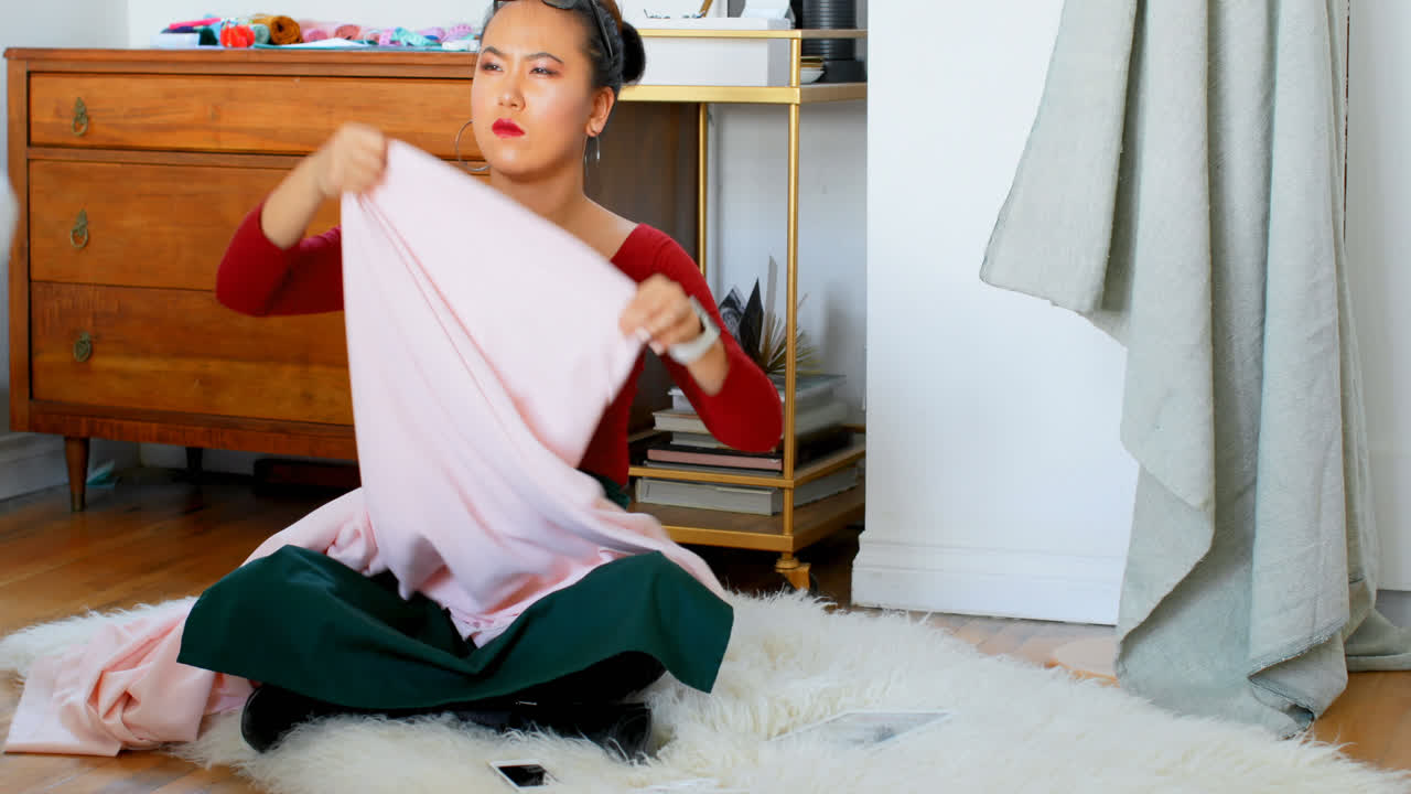 패션 디자이너가 직물을 검사하는 4k