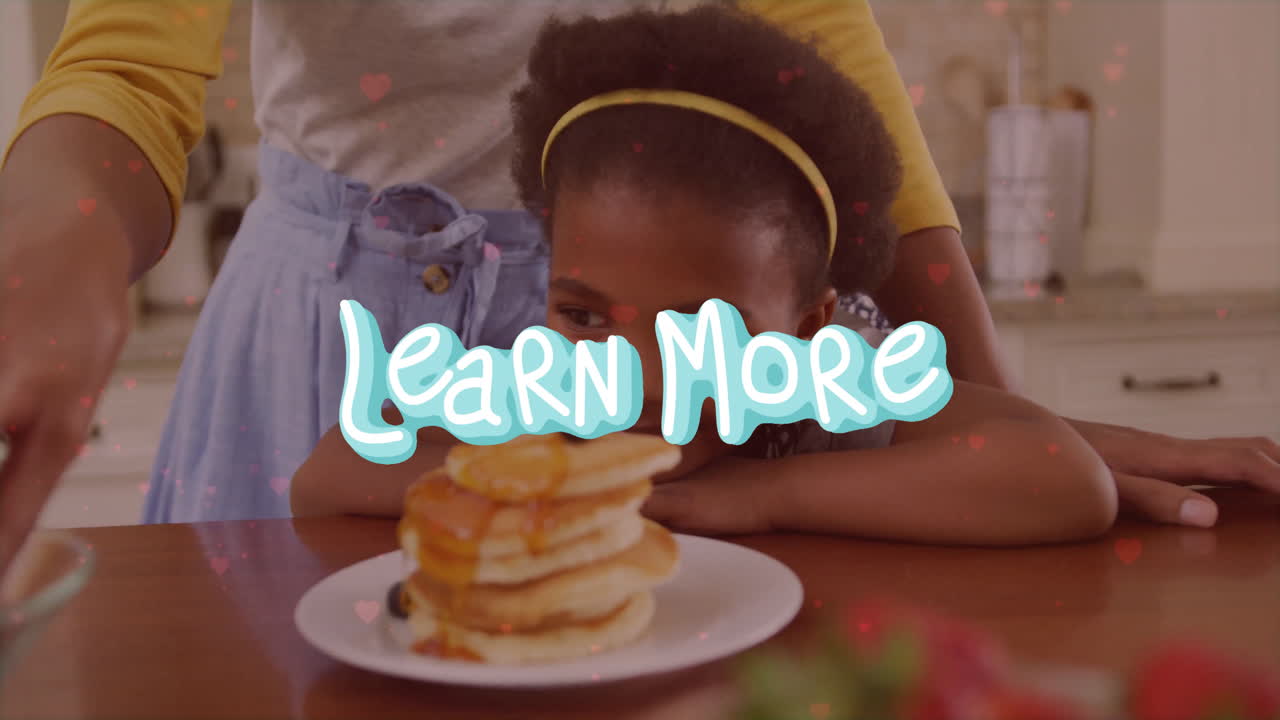 In kitchen, child watching animation about pancakes with Learn More text overlay