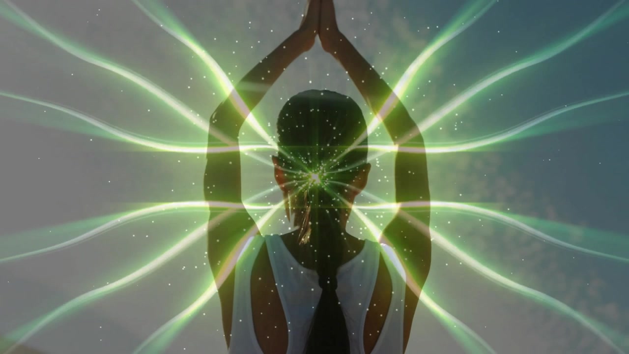 Kvinna som utövar yoga med glödande energifält