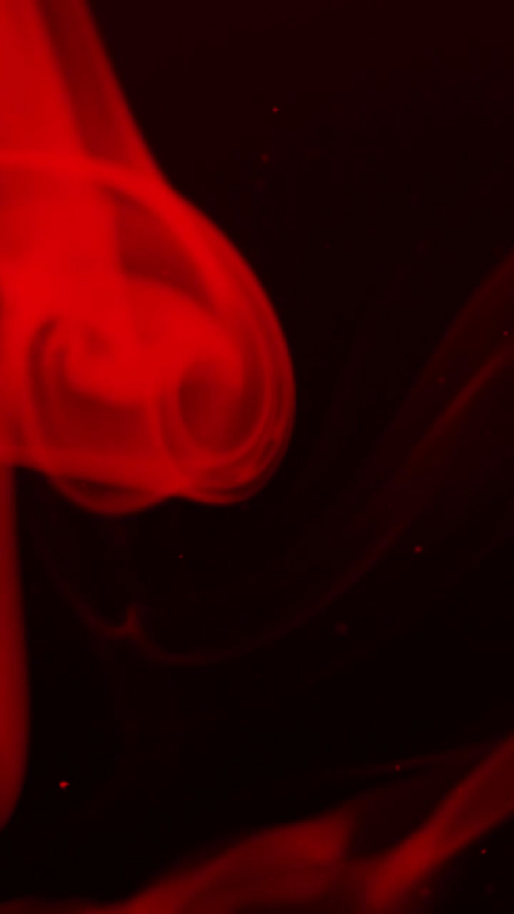 Fumo rosso atmosferico e particelle su sfondo nero