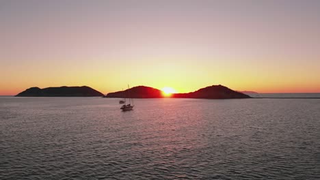 Pink-orange-sunset-above-sea,-a-bay-with-two-small-boats-in-San-Carlos,-Mexico