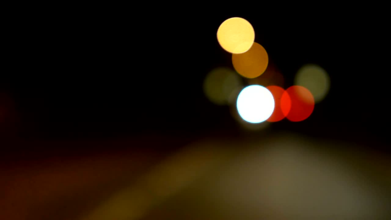 conducir un coche a través de la carretera de la noche, la autopista. luces desenfocadas calle de los ángeles resumen. ciudad fondo borroso. movimientos círculos bokeh de tráfico nocturno.