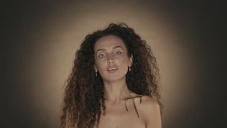woman with gold makeup and curly hair