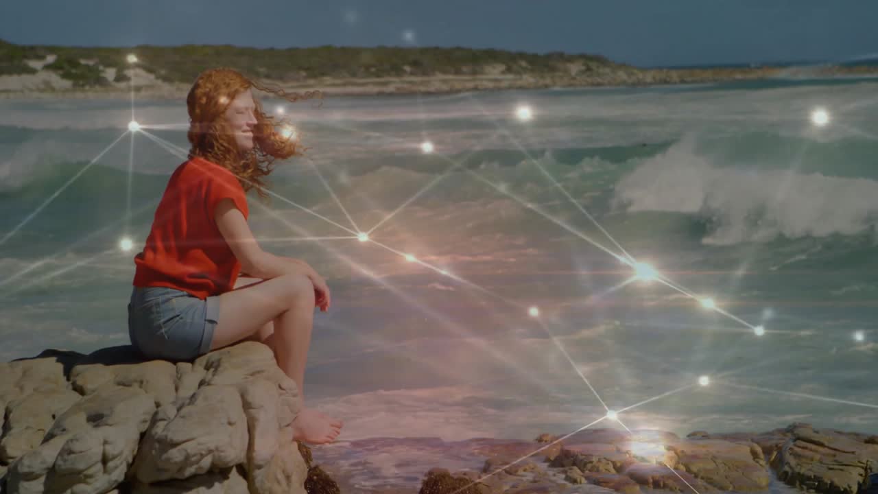 woman brushing hair following glowing overlay drifting then fading over ocean showing tech data