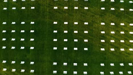 aerial view of white chairs in rows on the green field during the graduation event of puget sound university in tacoma, washington