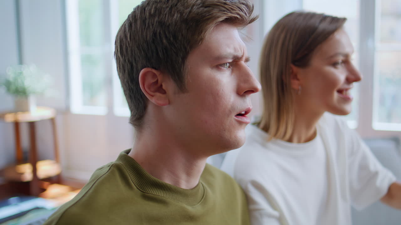 Youngsters enjoy video game laughing at home closeup. Gamers playing on consoles