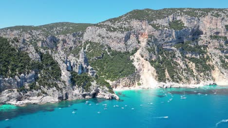 baunei coast and cala goloritze beach - tourist boat excursions during vacation in sardinia, italy - aerial 4k