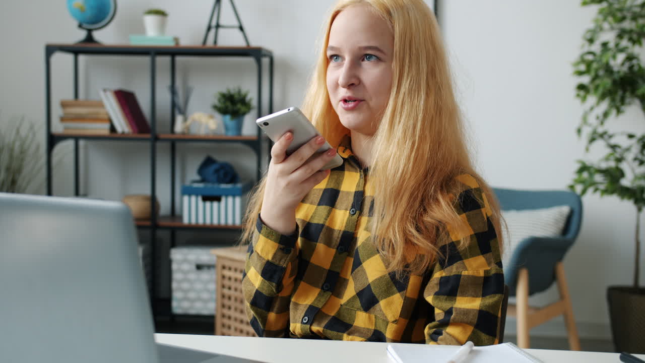 Teenage girl studying and using her smartphone