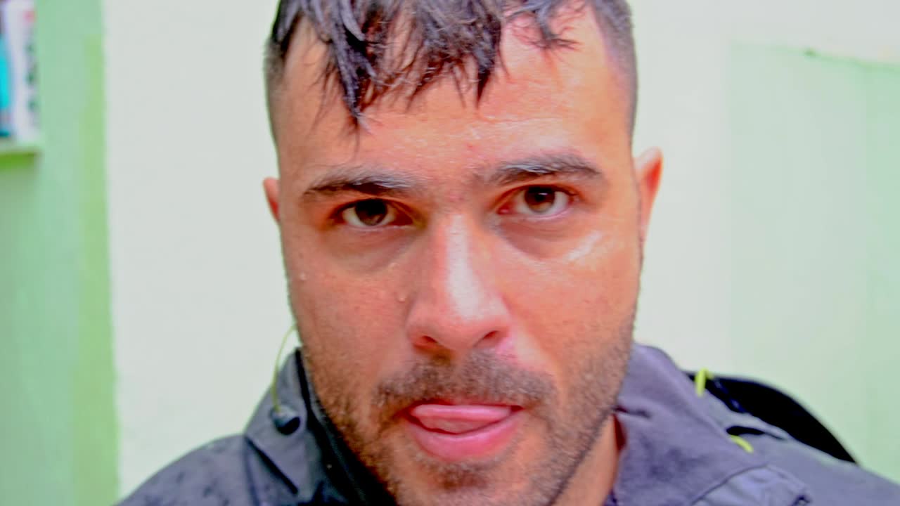 Man is taking his work goggles offn and licking his own mouth