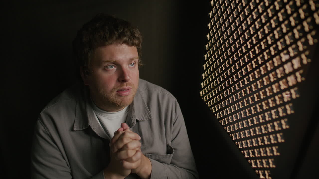 Devout Man Praying with Hands Clasped during Confession with Priest
