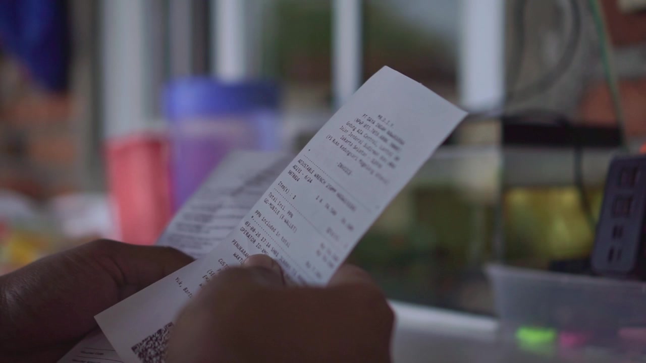 hand of person checking printed receipt, reviewing bill and QR code, financial transaction and shopping concept