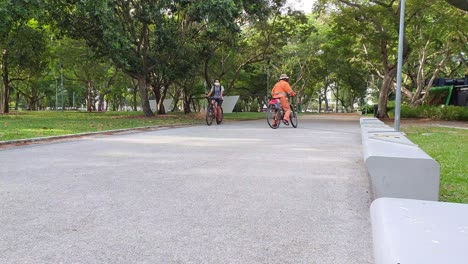 cleaner riding bicycle with face mask during lockdown in a public park in singapore, asia