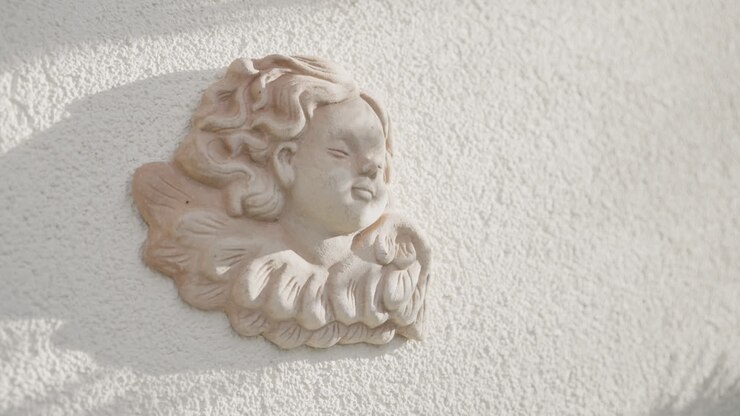 Scultura di angelo beige su una parete