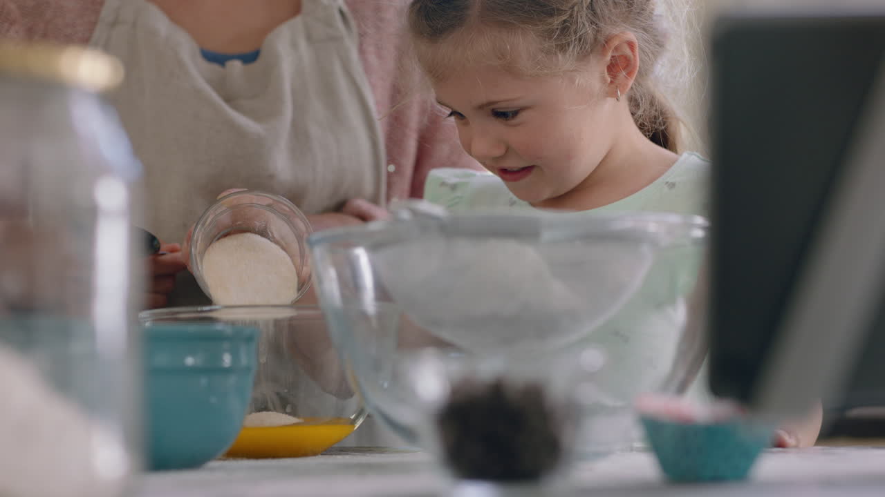 little girl helping mother bake in kitchen mixing ingredients baking cookies preparing recipe at home with mom teaching her daughter on weekend