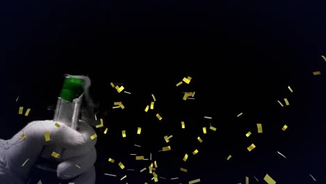 Confetti-falling-over-mid-section-of-person-opening-a-champagne-bottle-against-black-background