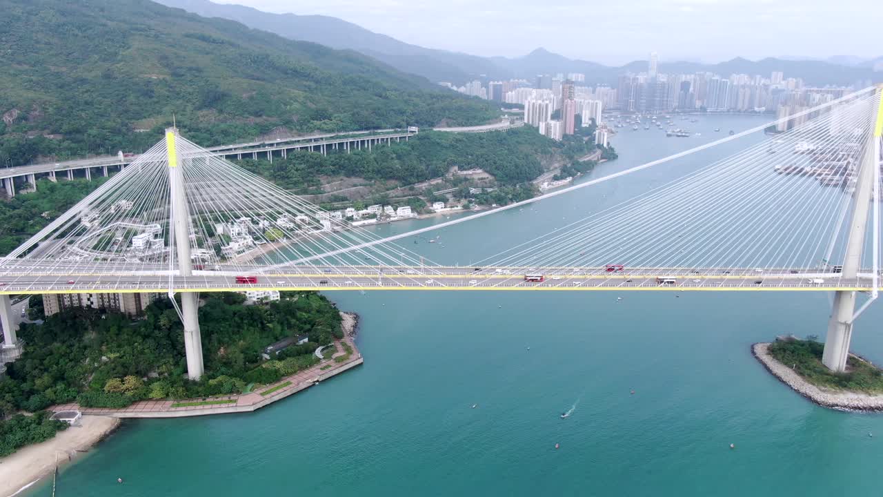 tráfico en un puente en la bahía de hong kong con edificios de la ciudad en el horizonte, vista aérea