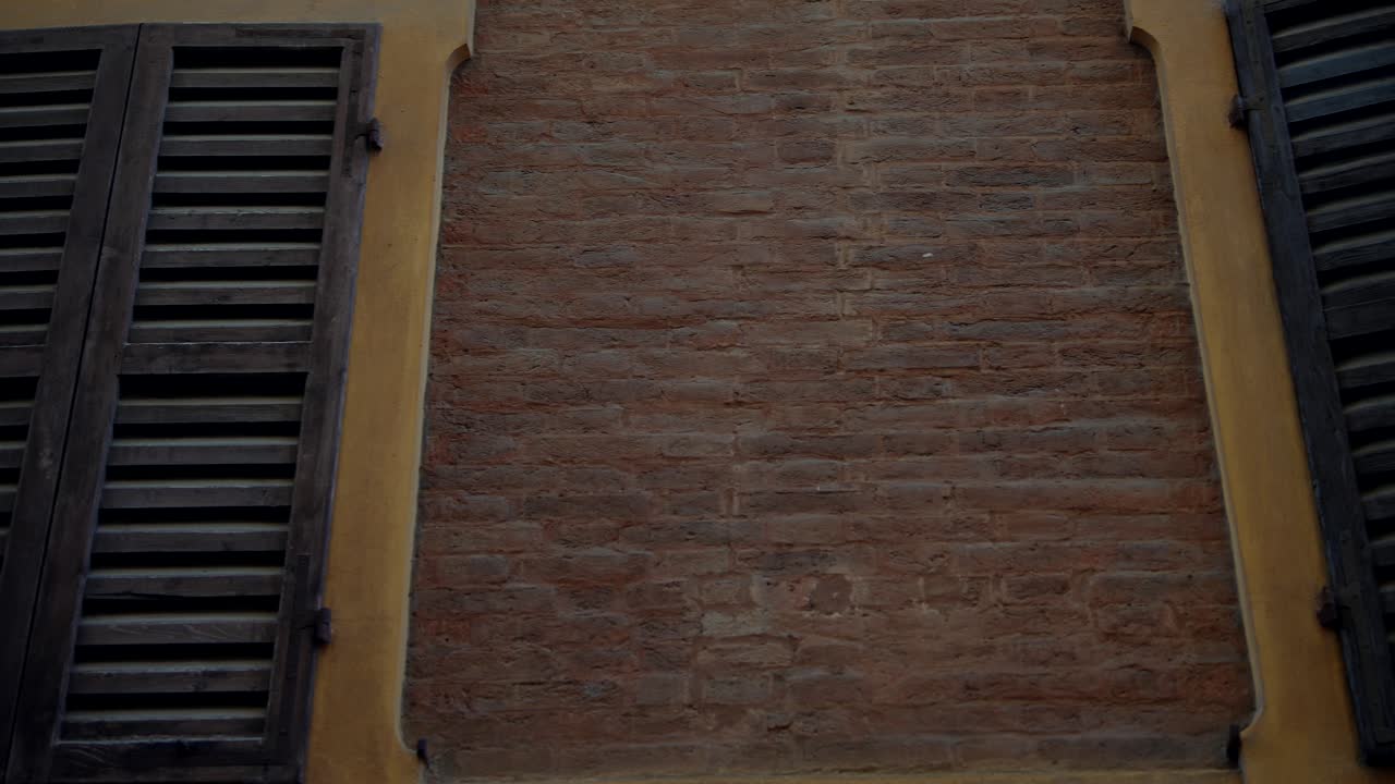 Exterior of an Old Building with Wooden Shutters and Brick Wall