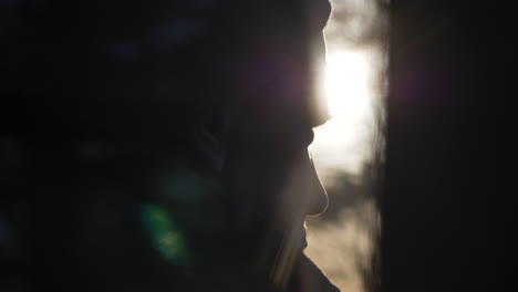 hipster traveler holding coffee mug in wooden cabin watching the sunrise