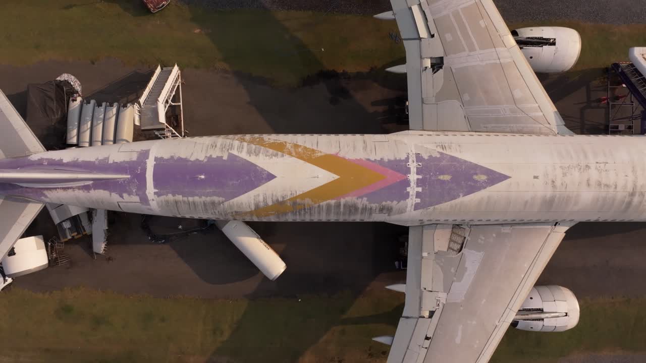 Vecchio aereo abbandonato vicino a una strada trafficata nella Thailandia rurale.