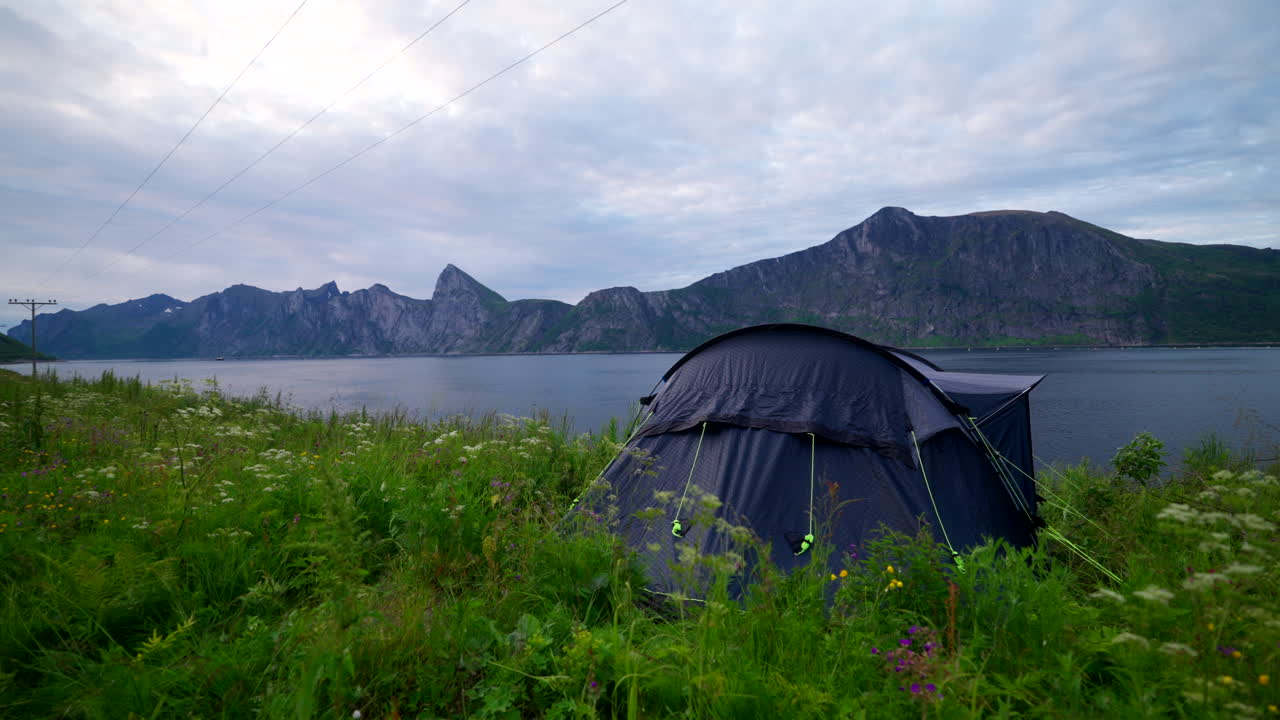 Tent Pitched In A Grassy Area Next To The Fjord In Mefjord, Senja, Norway. - zoom in shot