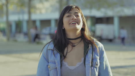 una adolescente alegre haciendo gestos al aire libre.