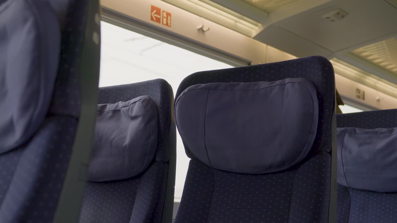 Interior of a German ICE high-speed train, empty seats with pillows visible