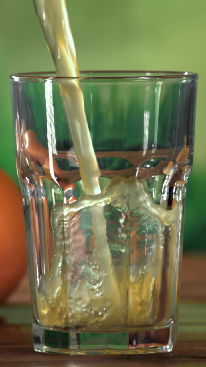Versamento al rallentatore di succo rinfrescante in un bicchiere