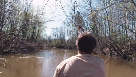 hombre en un río en un bosque