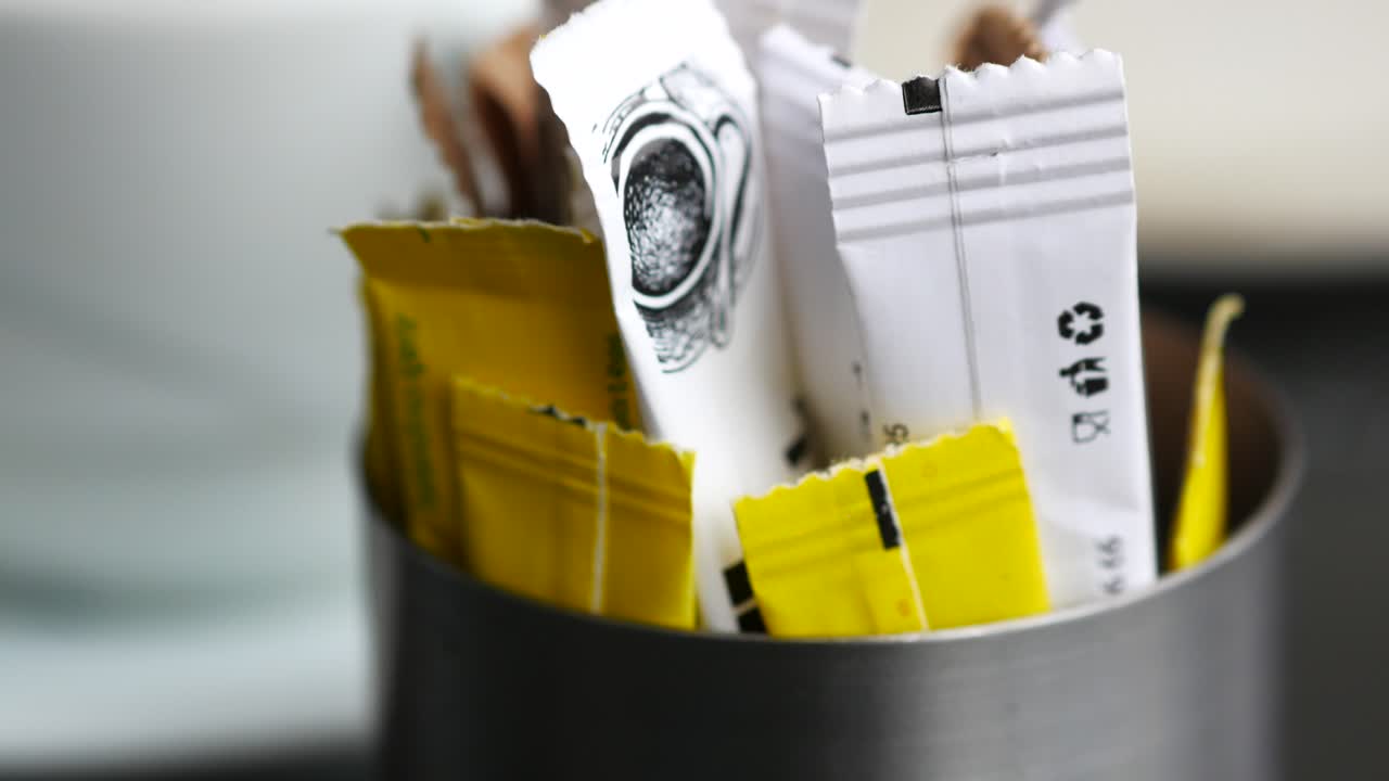 Spoon of white sweetener on a black background