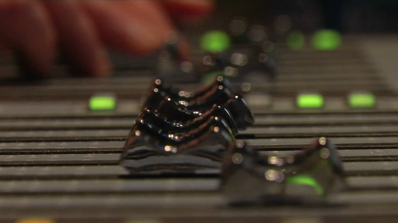 los dedos empujan los controles deslizantes en una placa de sonido