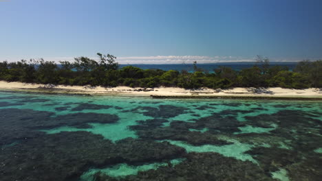 Low-flyover-above-small-tropical-island-near-Isle-of-Pines,-New-Caledonia