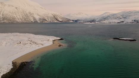 disparo de drones inclinándose hacia arriba para revelar un hermoso paisaje montañoso nevado, escandinavia