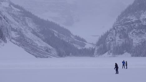 Patinadores-Sobre-Hielo-En-El-Lago-Louise-Congelado-Invierno,-4k