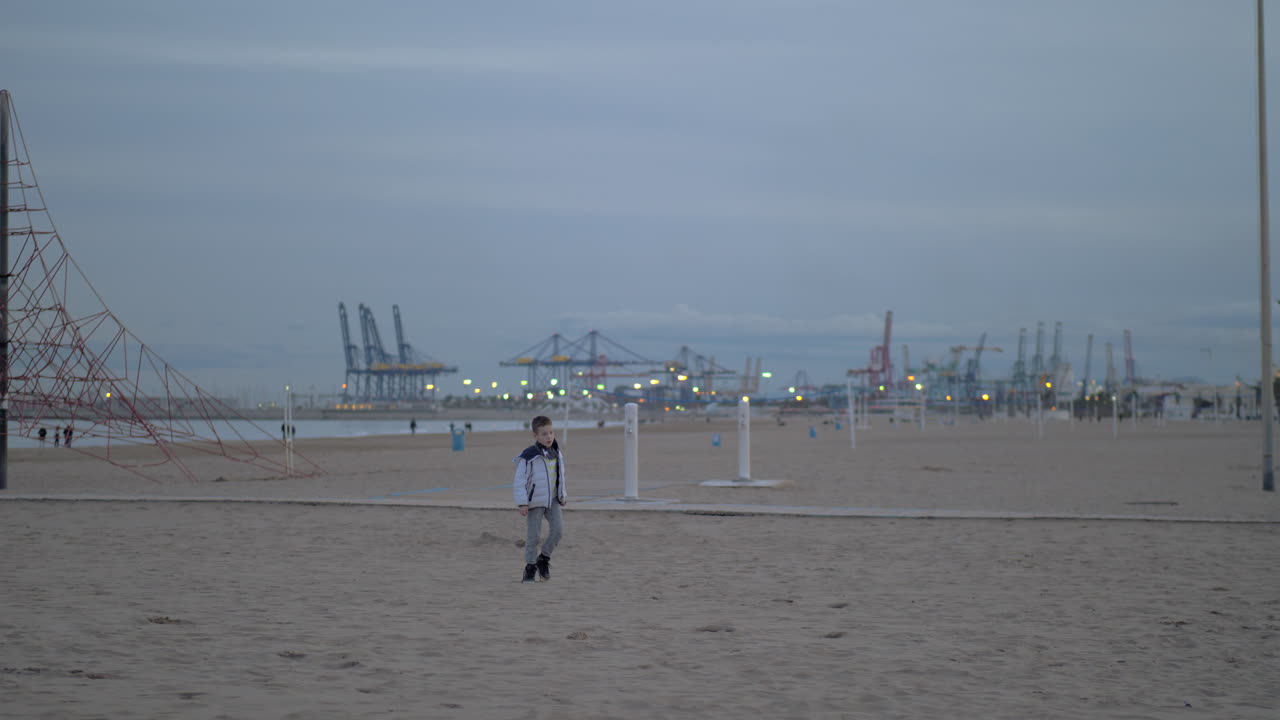 차가운 날 해변을 고 있는 어린 소년