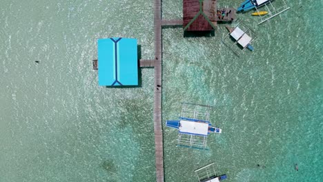 Draufsicht-Auf-Banca-Doppelauslegerboote,-Die-Am-Pier-Auf-Den-Balabac-Inseln-Vor-Anker-Liegen