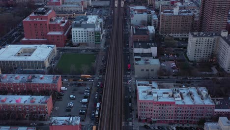 curved drone flight over elevated train tracks of harlem, new york city just after sunrise