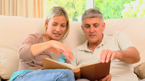 attractive couple looking through album and smiling