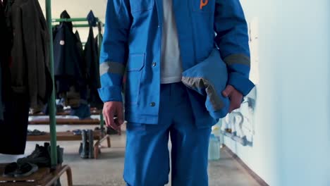 trabajador en uniforme azul llevando un objeto