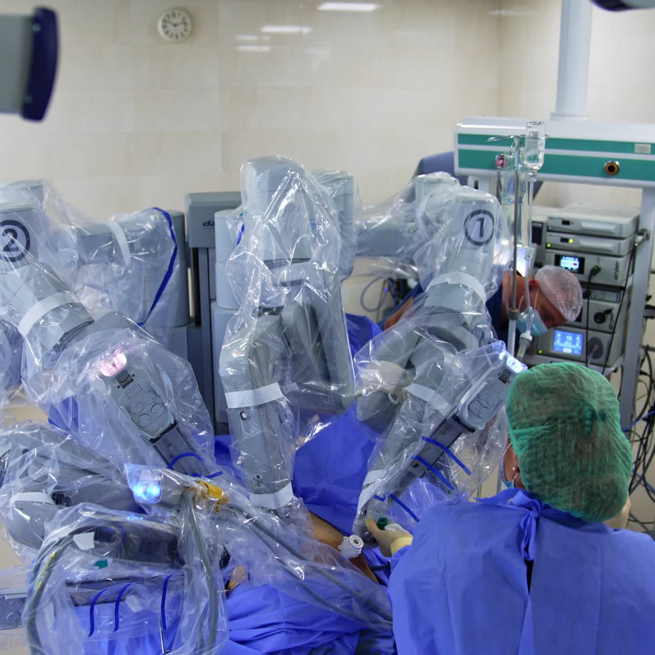 Da Vinci robot surgery in modern clinics. Innovative equipment in the middle of operational room over the patient. Medics watch and direct the work of machine