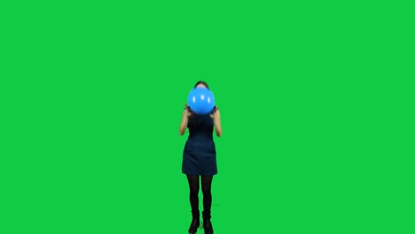 girl playing with the balloon in front of a green screen