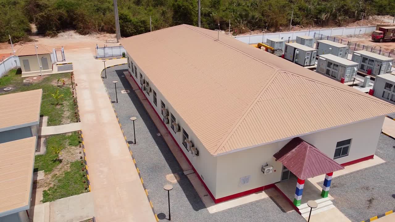 Aerial right panning shot of building facilities and modern modular LiFePo Battery Energy Storage and Conversion Systems at Renewable energy solar farm